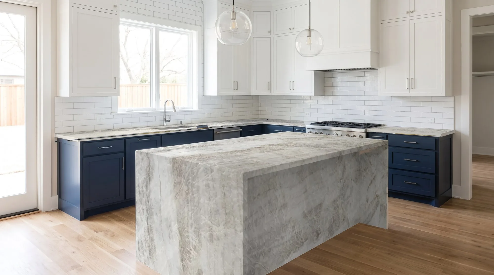Kitchen with a Taj Mahal quartzite waterfall island and matching perimeter counters